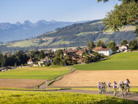 Switzerland-Day-3-Far-Scenic-Shot-Of-Pack-Cycling-Out-Of-Small-Village